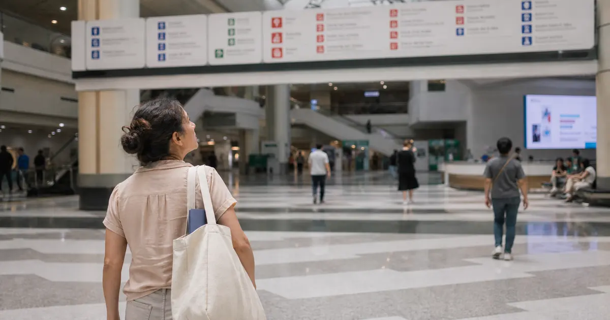 International visitor looking for directions in a busy hospital atrium in China