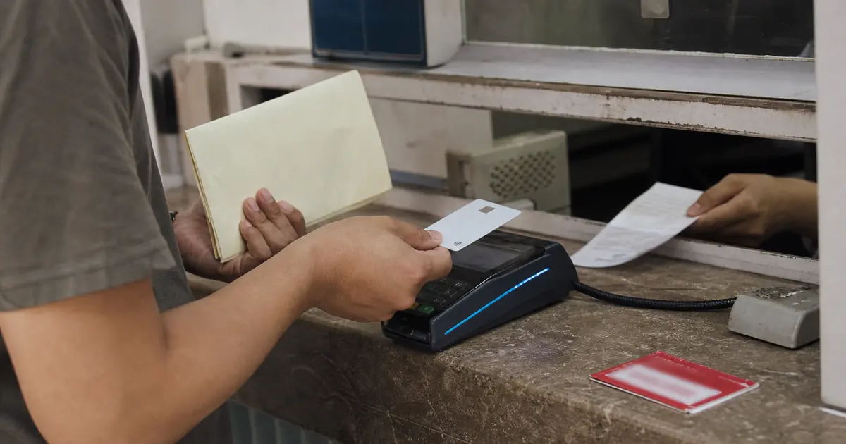 International visitor making a card payment at a hospital cashier window